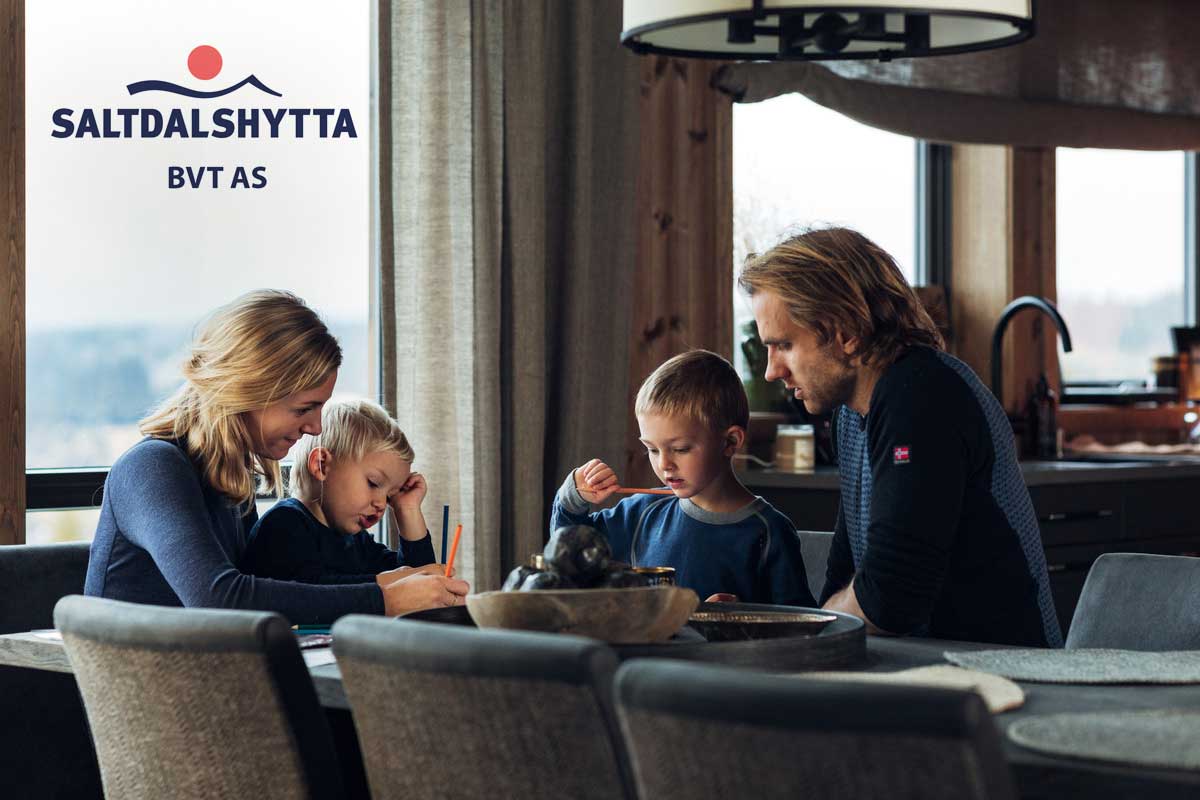 familie-sitter-rundt-spisebord-med-logo saldalshytta